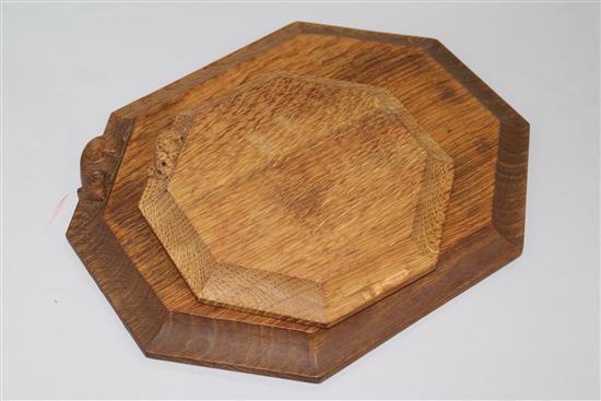 A Robert Mouseman Thompson octagonal bread board with signature mouse and a similar pot stand W 30cm & 19cm